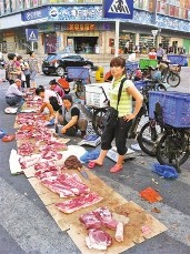 地上铺纸板当街卖猪肉(图)