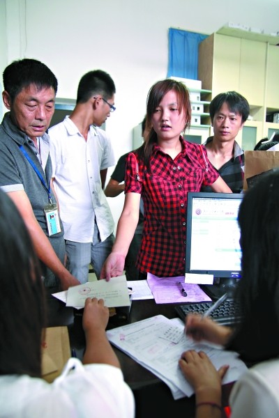 右图:昨日,付欢在办理入学手续.